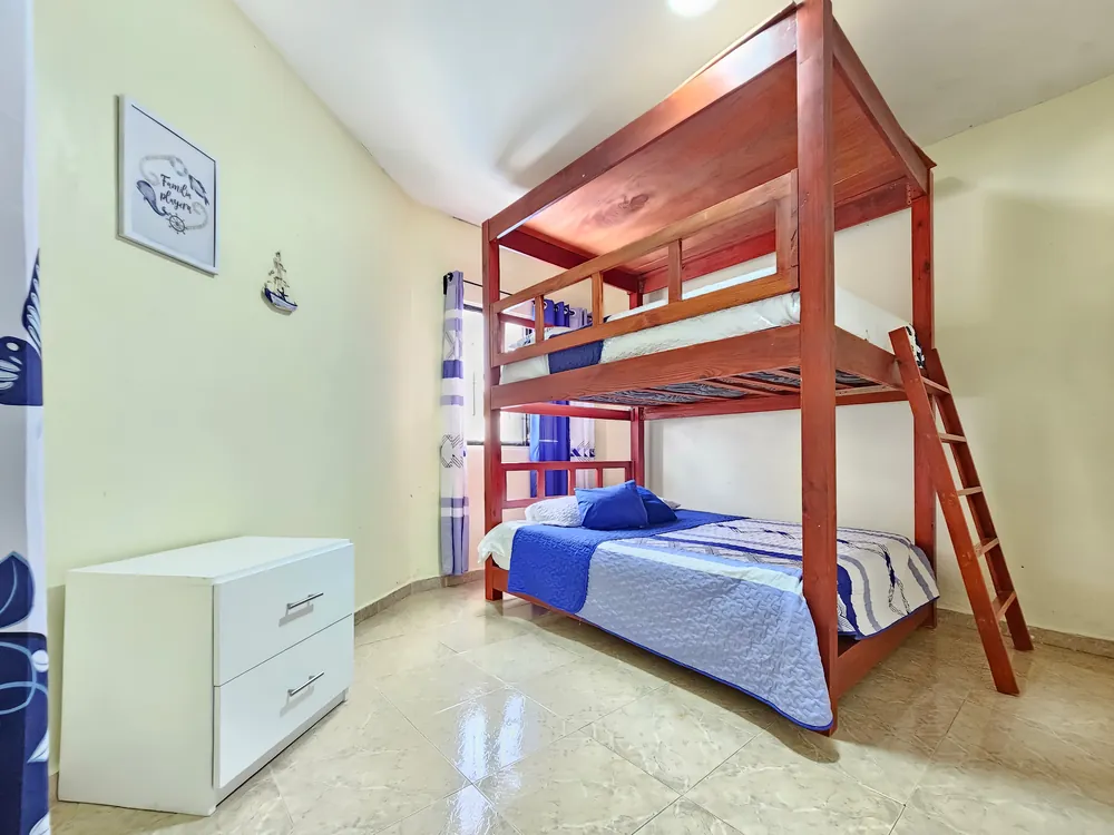 A bunk room: a double below, a single above, and a wooden ladder
